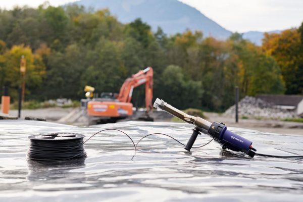 Detalhe da soldagem de geomembrana com a extrusora manual Weldy Booster EX3 em área de construção.