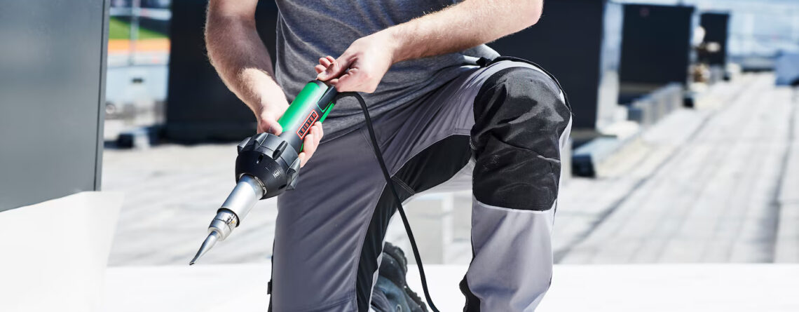 Técnico realizando soldagem de manta sintética em cobertura com ferramenta de ar quente Leister TRIAC, aplicada em serviços de manutenção e impermeabilização de telhados