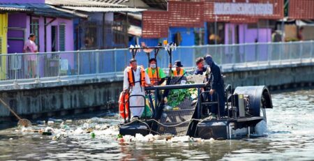 Barco coletor de resíduos em PEAD operando nos canais de Bangkok, com estrutura soldada utilizando tecnologia de soldagem plástica Leister para aplicações ambientais