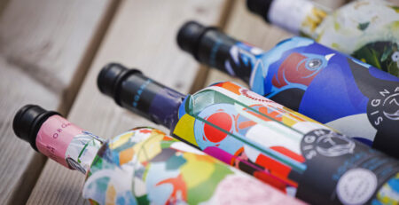 Garrafas Frugal Bottle de papel em close, com rótulos coloridos, mostrando a variedade de embalagens produzidas com precisão e aquecimento controlado Leister