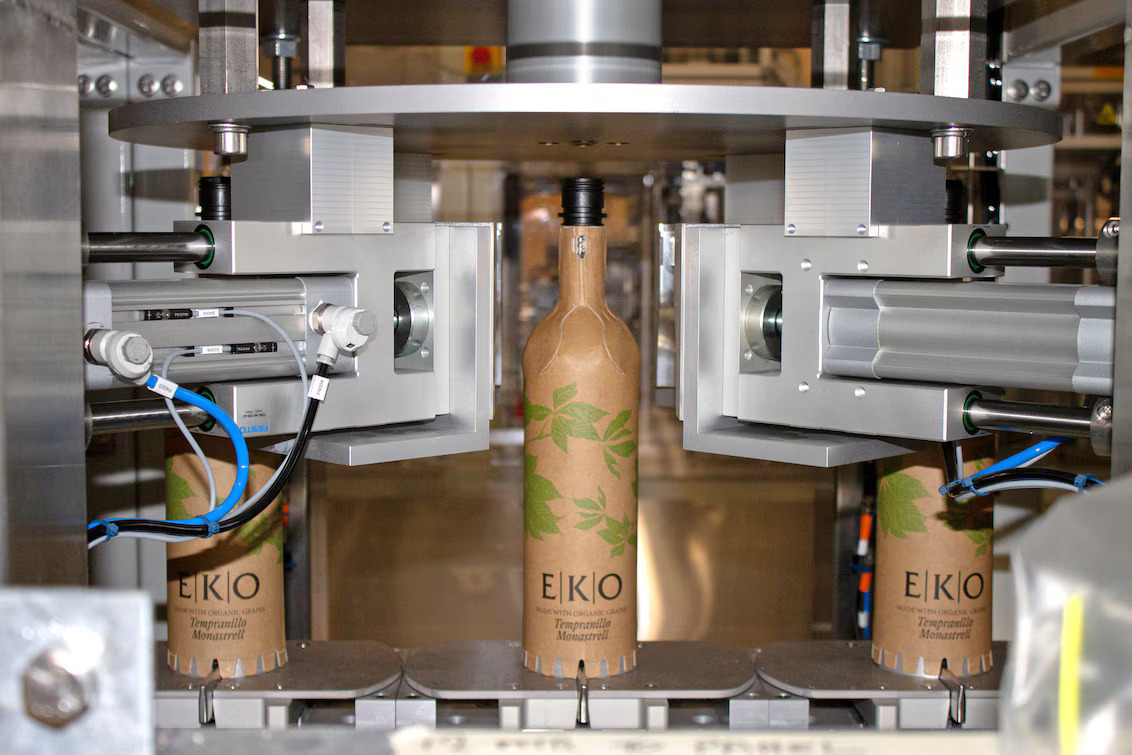 Máquina automatizada moldando garrafas de papel Frugal Bottle com aquecimento e conformação industrial, processo viabilizado por sistemas de ar quente Leister